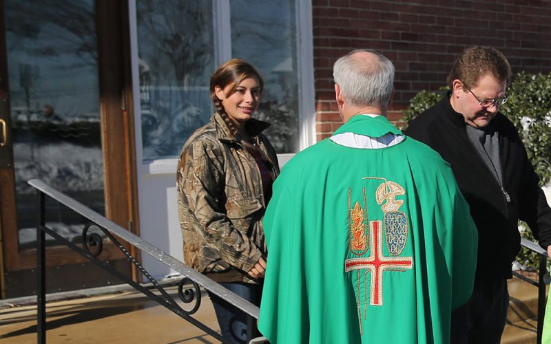 pastor greets parishioners