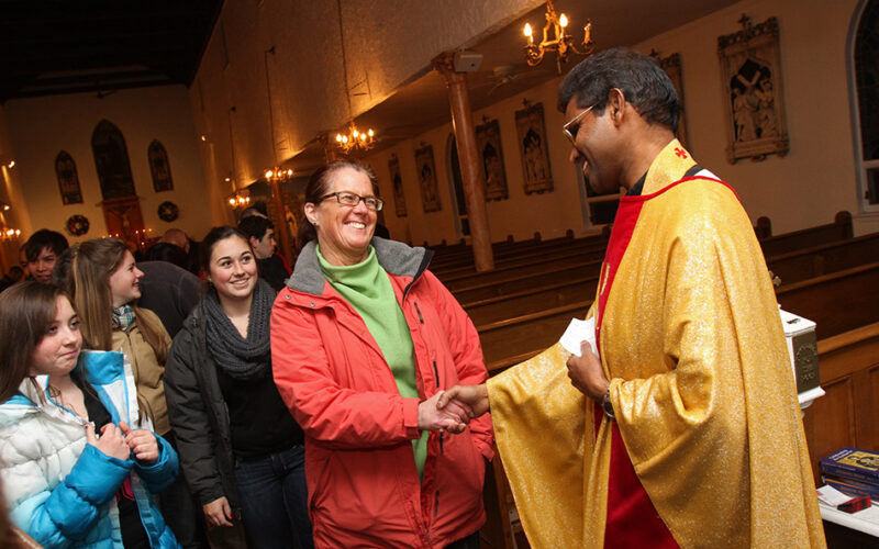 priest greets parishioners