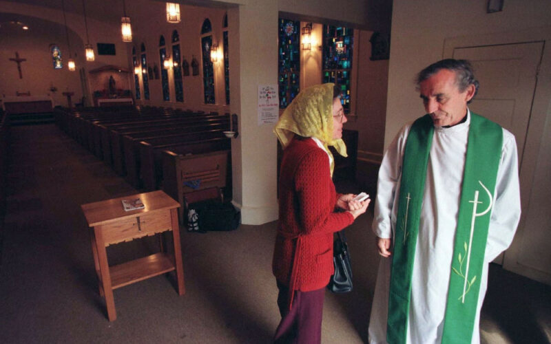 Priest talks to parishioner